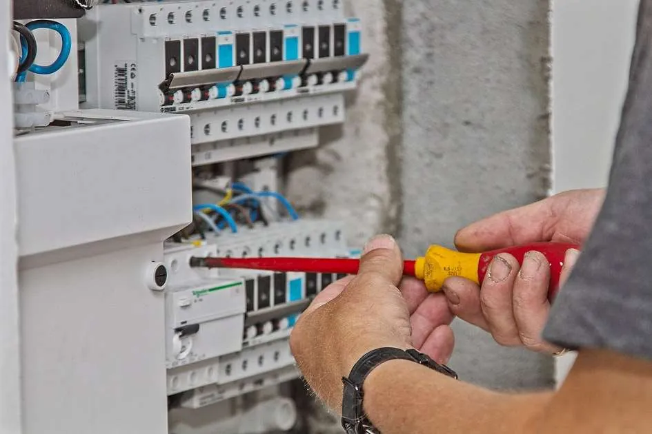 Elektriker arbejder i en gruppetavle